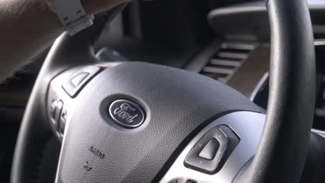 Hand-held-close-up-of-car-steering-wheel-with-driver´s-hand