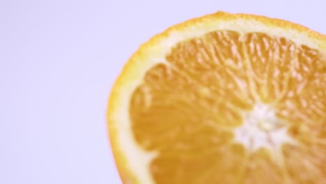 Close-up-fresh-valencia-orange-sliced-with-white-background-shallow-focus-and-slowly-rotating