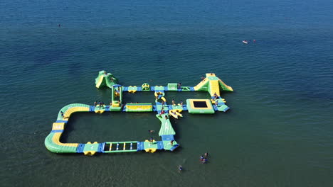 Aerial-shot-for-people-swimming-and-having-fun-in-the-sea-and-kids-play-at-water-inflatable-games