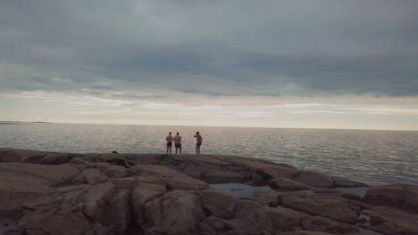 Young-men-visiting-at-a-beach-shoreline-enjoying-a-beautiful-sunset