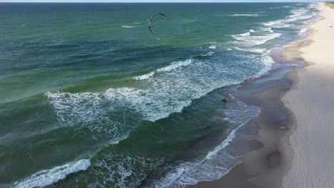 AERIAL:-Rotating-Shot-of-Stranded-Surfer-Waiting-for-a-Wave-on-a-Beach-on-a-Sunny-Day
