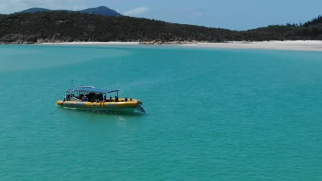 Barco-Turístico-Inflable-Y-Playa-De-Whitehaven-En-El-Fondo,-Australia