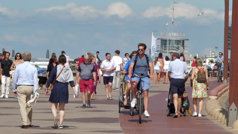 Gente-Caminando-Y-Andando-En-Bicicleta-En-El-Paseo-Marítimo-De-La-Playa-De-Knokke-heist-En-Un-Día-Soleado-De-Verano-Durante-La-Pandemia-De-Coronavirus-En-Flandes,-Bélgica