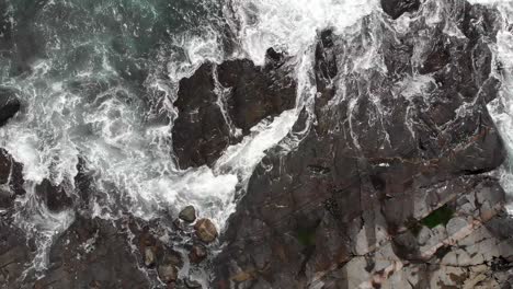 Aerial:-stormy-waves-crashing-on-rocky-coastline