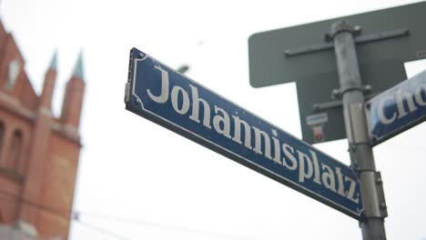Close-Up-of-Johannisplatz-Street-Sign,-Wiener-Platz,-Munich-Germany,-Slow-Motion