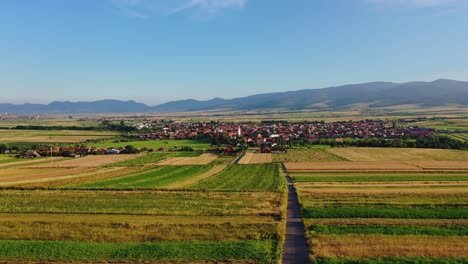 Flying-towards-Sancraieni,-idyllic-European-village-among-farmland,-Romania
