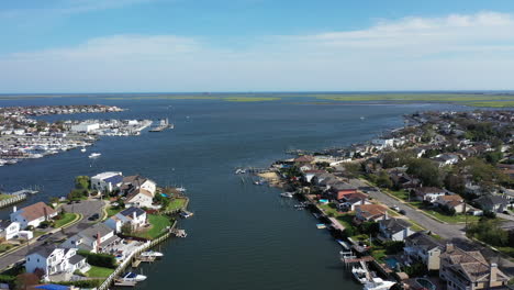 An-aerial-drone-shot-over-a-channel-leading-out-to-East-Bay-on-Long-Island,-NY