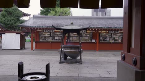 Asakusa-Sensoji-shrine-in-rain-with-people-passing-through-holding-umbrella---locked-off-view