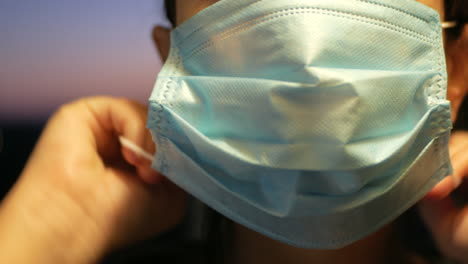 Frau-Setzt-Gesichtsschutzmaske-Auf---Coronavirus-Prävention