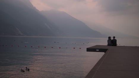 Couple-enjoy-romantic-sunrise-together,-mountain-breathtaking-view,-Lake-Garda