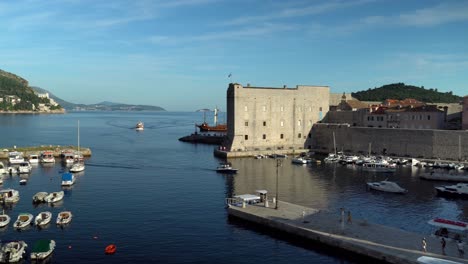 Schwenkblick-Auf-Den-Hafen-Gleich-östlich-Der-Stadtmauer-In-Der-Altstadt-Von-Dubrovnik-Mit-Ein--Und-Ausfahrenden-Booten