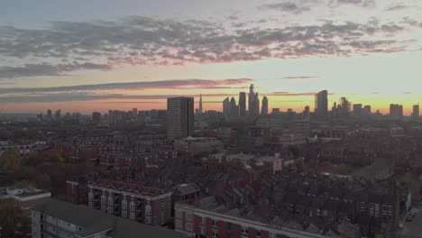 Aufsteigende-Drohne-Schoss-Londoner-Wohngebäude-Zu-Einem-Ikonischen-Sonnenuntergang-In-Der-Innenstadt