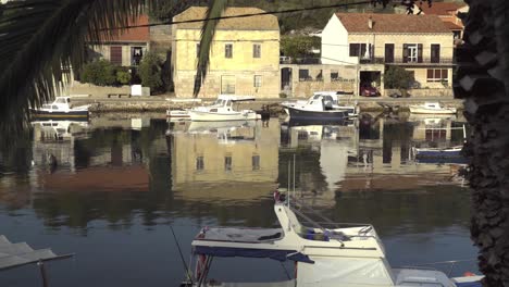 Boote,-Die-Entlang-Einer-Straße-In-Vela-Luka-In-Kroatien-Angedockt-Sind,-Mit-Klarer-Spiegelung-Im-Wasser