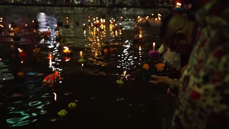 Thai-man-holds-the-Loy-Krathong-and-prays-at-City-Canals-at-night-during-Loi-Krathong-celebrations-in-Korat,-Thailand