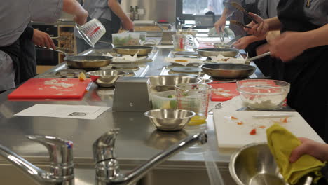 Estudiantes-Ocupados-Preparando-Comida-Durante-La-Clase-De-Cocina-En-La-Escuela-Secundaria