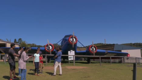 Touristen,-Die-Fotos-An-Der-Nachbildung-Des-Stinson-flugzeugs-Machen---O&#39;reillys-Regenwaldrückzugsort-Im-Lamington-Nationalpark---Canungra,-Gold-Coast,-Qld,-Australien