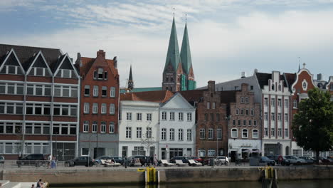 Static-wide-shot-showing-old-cityscape-and-church-of-Lübeck-in-background-on-sunny-day,Germany