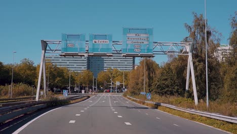 Blick-Auf-Das-Ende-Der-Leeren-Autobahn-In-Einer-Stadt-Mit-Straßenschildern-Darüber-In-Den-Niederlanden