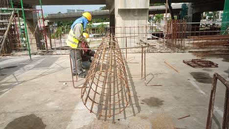 Bauarbeiter-Installieren---Fertigen-Holzschalungen-Und-Bewehrungsstäbe-Auf-Der-Baustelle