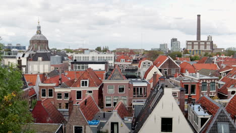 Aerial-wide-shot-over-Leiden-City-with-old-town,-Marekerk-church-and-factory-in-background-during-autumnal-day