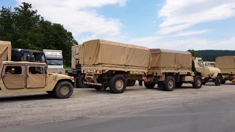 American-Army-Vehicles-Parked-On-The-Roadside-In-Omurtag,-Bulgaria---View-From-A-Moving-Vehicle