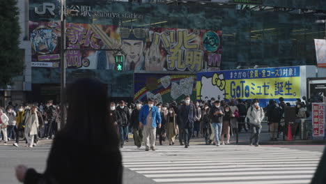 Pedestrians-Cross-At-Shibuya-Scramble-Crossing-With-JR-Shibuya-Station-In-Background-During-COVID-19-In-Tokyo,-Japan
