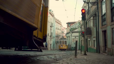 Lisbon-Alfama-ancient-medieval-vintage-stone-pavement-street-railway-trams-crossing-at-low-angle-4K-16:9