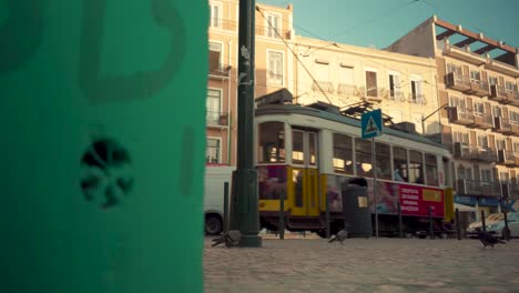 Lisbon-typical-neigborhood-square-with-promenade-terrace-tram-passing-by-at-sunrise-4K