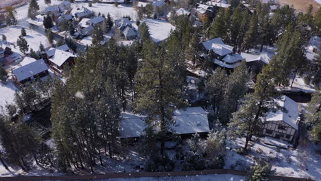 Aerial-wooden-cottages-Winter-resort-covered-by-pure-white-snow-during-snowfall