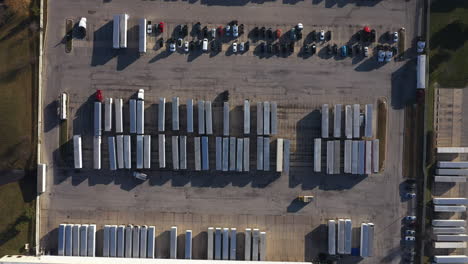 Top-down-aerial-pan-high-above-a-parking-lot-full-of-semi-trailers-and-trucks-near-Chicago