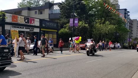 3-3-Miles-De-Manifestantes-Antimáscara-Marchan,-Andan-En-Bicicleta-Con-Globos-Y-Medio-Enmascarados-Mientras-Las-Motocicletas-Escoltas-De-La-Policía-Los-Ayudan-A-Compartir-Con-Megáfonos-Carteles-Publicitarios-Sus-Teorías-De-Conspiración-No-Probadas