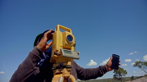 Skilled-man-uses-a-theodolite-while-surveying-a-construction-site