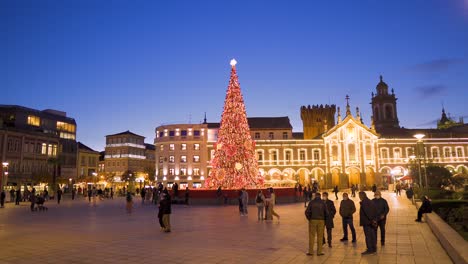 Braga-Portugal-December-2nd-2020-Lit-up-Christmas-tree-with-lights-surrounded-by-people-with-masks-in-the-main-square-of-the-historic-city-centered-static-shot