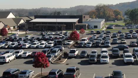 Aerial-truck-shot-of-cars-driving-and-turning-at-large-church-parking-lot