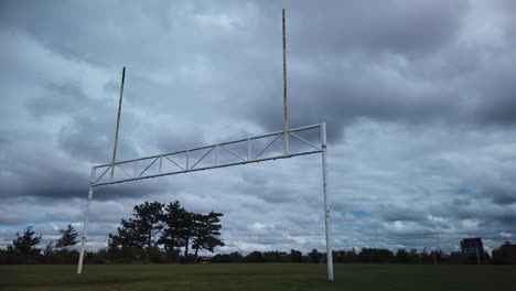 Lapso-De-Tiempo-Diurno-Enmarcado-Bajo-De-Nubes-En-Movimiento-Rápido-Sobre-Postes-De-Fútbol-Y-Campo