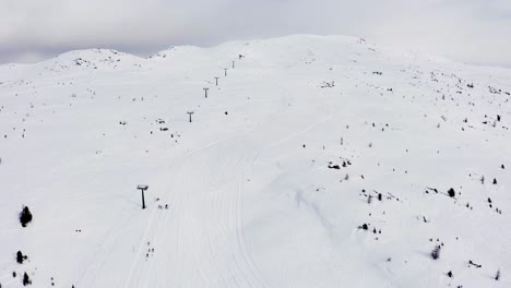 Aerial-view-of-empty-snowy-winter-ski-slope-Ski-Area-named-Alpe-Lusia-in-Italy