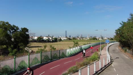 Lugareños-Usando-Un-Carril-Bici-En-Hong-Kong-Con-El-Horizonte-De-Shenzhen-En-El-Horizonte