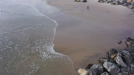 Ein-Luftbild-über-Einen-Steinsteg-An-Einem-Ruhigen-Strand-Am-Morgen