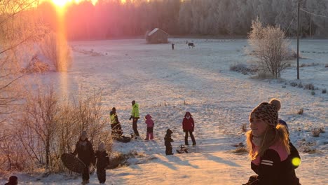 Group-of-people-snow-tubing-down-a-slope-in-beautiful-winter-weather,-in-Vaasa,-Finland