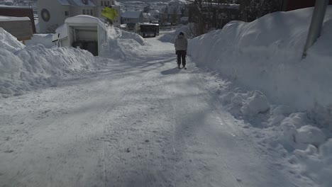 Zeitlupenaufnahme-Von-Skifahrern-Beim-Skifahren-Auf-Den-Verschneiten-Straßen-Der-Stadt-Tromso-An-Einem-Sonnigen-Tag-In-Norwegen