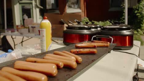 Hotdogs-cooking-on-electric-skillet-at-outdoor-street-fair,-Slow-Motion