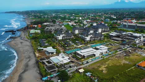 Cinematic-drone-footage-of-Berawa-beach-in-Canggu,-Bali-with-beautiful-landscape,-expensive-hotels-and-villas-through-calm-weather