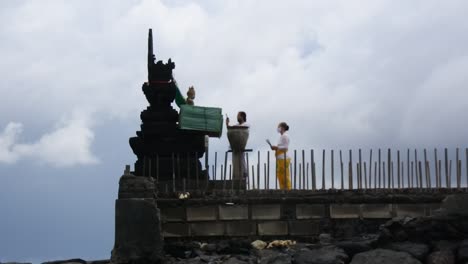 Una-Mujer-Balinesa-Dando-Ofrendas-Cerca-Del-Templo-De-La-Playa-Del-Estuario,-Bali,-24-De-Noviembre-De-2020