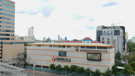 Paisaje-Urbano-Con-El-Edificio-Bawaslu,-Yakarta.-Vuelo-Aereo-Hacia-Atras