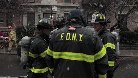 Gruppe-Von-Feuerwehrleuten,-Die-Den-Kegelstromunfall-In-Brooklyn,-New-York,-Unter-Starkem-Schnee-Auswerten---Breiter-Schwenk