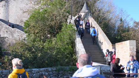 Weite-Aufnahme-Eines-Touristen,-Der-Während-Einer-Pandemie-Die-Treppe-Nach-Oben-Zum-Schloss-Mont-St-Michel-Geht