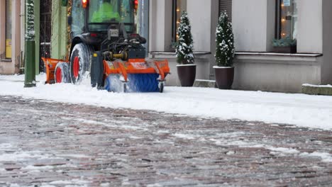 Snow-plower-tractor-cleaning-pavement-for-pedestrians