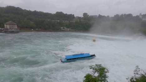 Boat-sailing-in-strong-river-current,-Rhine-Falls-waterfall-rough-waters