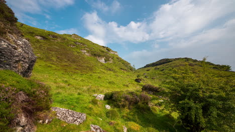 Panorama-Bewegungszeitraffer-Der-Ländlichen-Landschaft-Mit-Großen-Felsen-Im-Grasfeldhang-Während-Eines-Bewölkten-Sommertages-In-Irland