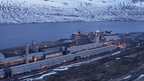Large-industrial-building-in-Iceland-fjord-early-morning,-aerial